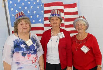 Three woman in front of American flag